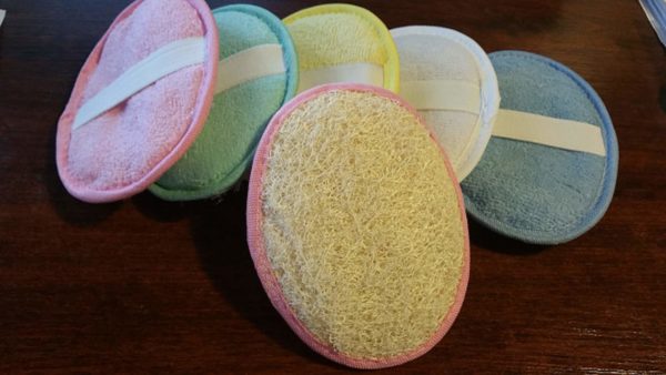 Six paumettes ovales de couleurs différentes avec élastique de maintien une face en loofah et une face en éponge.