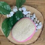 Une paumette ovale confectionnée en loofah, de couleur rose.